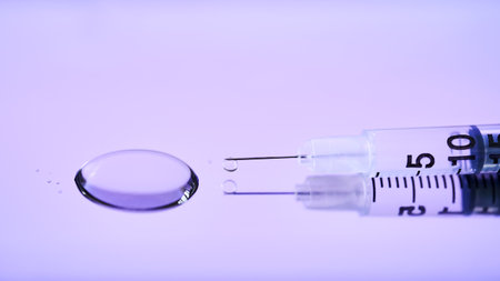 Injection syringe on a medical tray in bright violet color.の写真素材