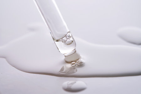 Dropper pipette with serum with drop close-up.