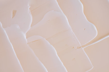 Swatch with white cream texture on a beige background.の写真素材