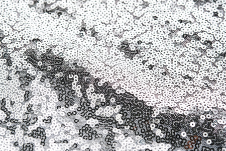 Abstract festive fabric texture with silver sequins.