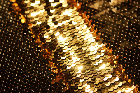Abstract festive gold background made of sequins.の写真素材