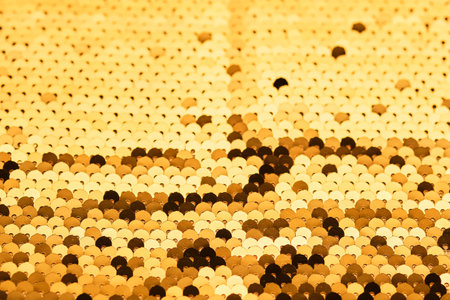 Abstract festive gold background made of sequins.の写真素材