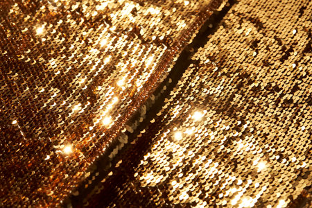 Abstract festive gold background made of sequins.の写真素材