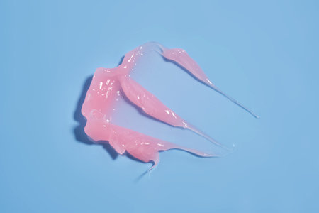 The texture of a pink lip mask or balm on a blue background.の写真素材