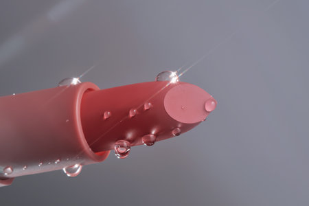 Classic lipstick with drops of water on a neutral background.の写真素材