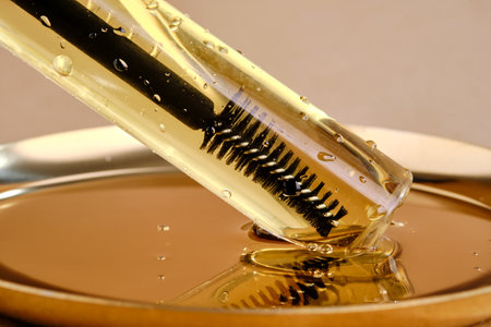 Bottle with brush filled with oil for eyebrow and eyelash growth. Texture.