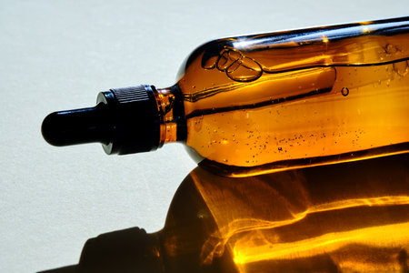 Serum for hair and scalp in a dark bottle in the light.