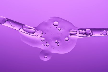 Two pipettes with serum on a lilac background.