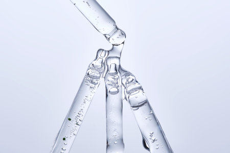 Four different face serum pipettes on a neutral background.の写真素材