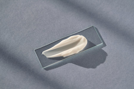 The texture of white cream on a slide on a blue background.の写真素材
