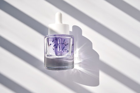 A bottle of face oil for all skin types with cornflower petals.の写真素材