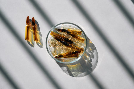 Ampoules on a gray background with stripes of shadows.の写真素材