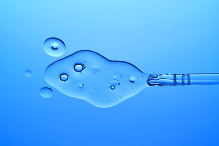A dropper with a transparent serum texture on a blue background.の写真素材