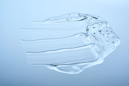A smear of gel serum texture on a blue background.の写真素材