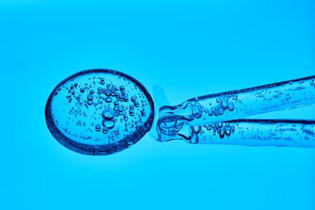 The texture of serum with spicules in a dropper on a blue background.の写真素材