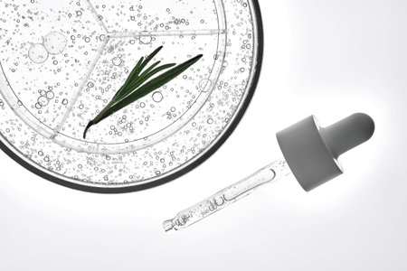 A sample of cosmetic gel with a sprig of rosemary and a dropper on a white background.の写真素材