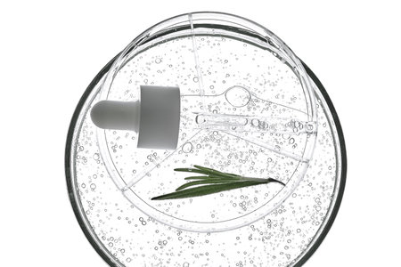 The texture of rosemary serum in a petri dish on a white background.の写真素材
