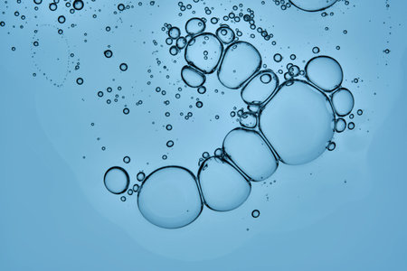 A beautiful drop of cosmetic product with bubbles on a blue background.の写真素材