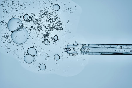 A pipette with hyaluronic serum on a blue background.の写真素材