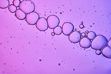 The texture of a cosmetic serum with a trail of bubbles on a purple background.