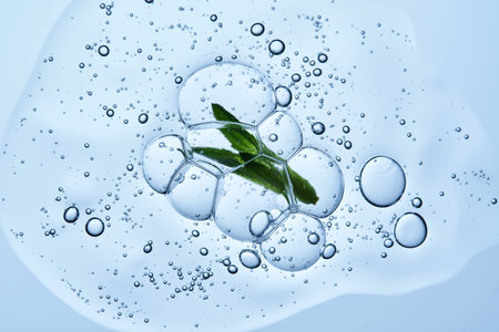 Beautiful texture of gel-like serum with a leaf on a blue background.の写真素材