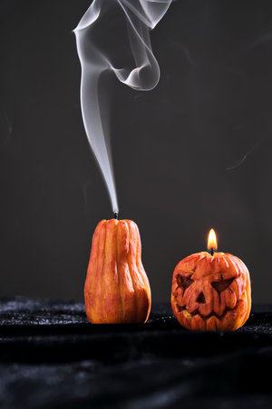 Halloween-style candles on a dark background. Festive decor.の写真素材