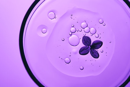 The texture of the serum in a petri dish with purple flowers.