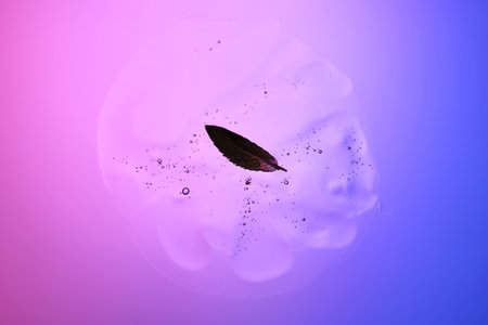 Beautiful texture of gel-like serum with a leaf on a purple background.