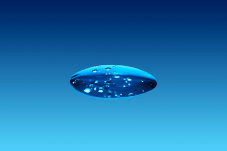 A drop of cosmetic product or serum on a blue background.