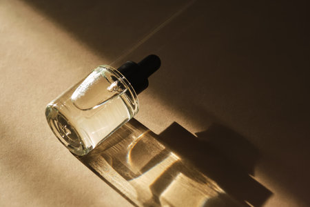 Natural facial oil with beautiful highlights on a beige background.
