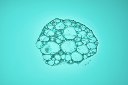 The texture of soap bubbles and foam in close-up on a green background.の写真素材
