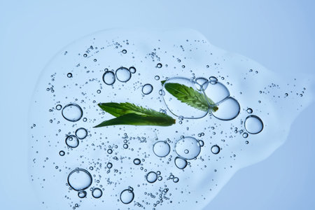 A drop of serum with bubbles and a green leaf on a blue background.