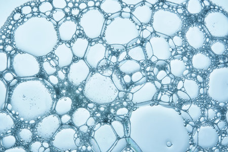 The texture of soap bubbles and foam in close-up on a blue background.
