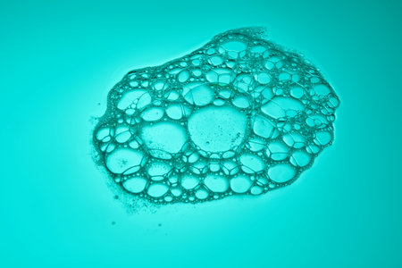 The texture of soap bubbles and foam in close-up on a green background.