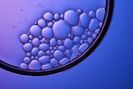 Serum with bubbles in a petri dish on a purple background.