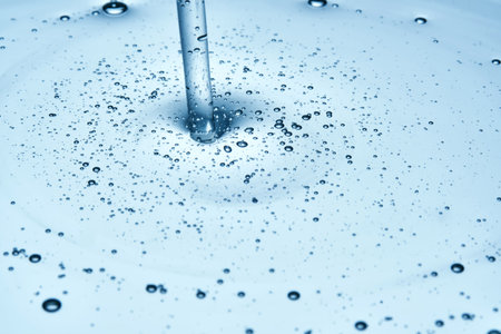Shampoo or shower gel is poured from above and shows a bubbly texture.