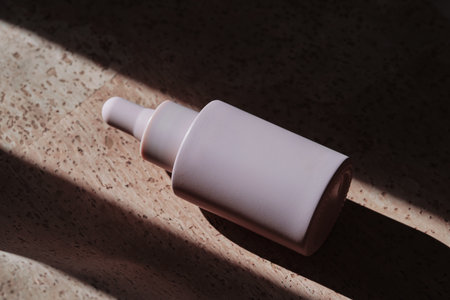 A bottle of facial serum on a cork background.
