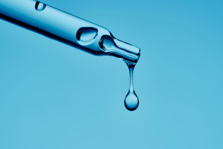 A serum pipette with lots of bubbles on a blue background.の写真素材