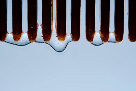 A comb with hair serum. The photo shows the texture of the cosmetic product.の写真素材