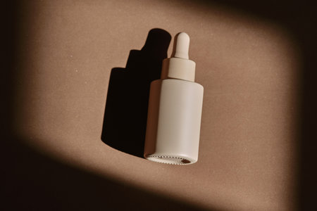 A bottle of face serum on a brown chocolate background.の写真素材