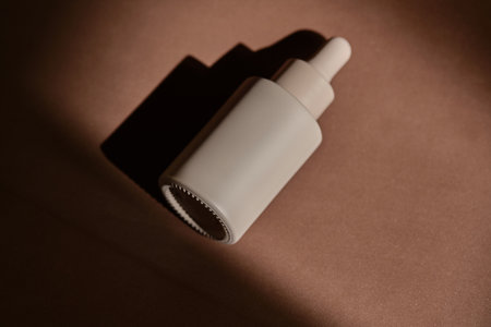 A bottle of face serum on a brown chocolate background.の写真素材