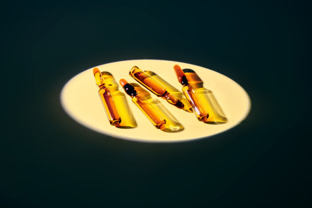 Several ampoules in the spotlight on a beige background.の写真素材