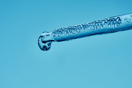 Gel hyaluronic serum in a pipette on a blue background.の写真素材