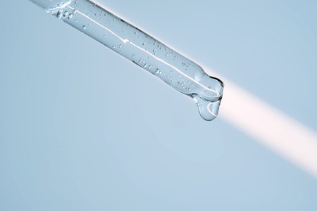A serum pipette with lots of bubbles on a blue background.の写真素材