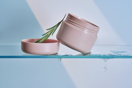A jar of rosemary cream on the glass shelf of the bathroom.