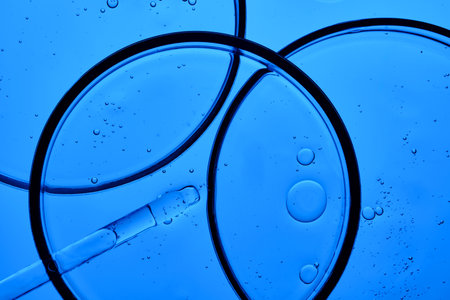 The texture of the serum in a petri dish on a blue background.の写真素材