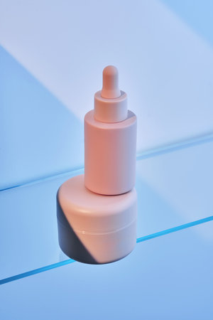 A bottle of serum and cream on the glass shelf.の写真素材