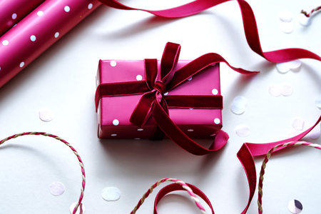 A light Christmas background with a red polka dot gift.の写真素材
