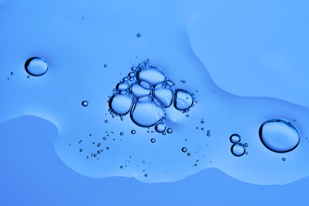 The texture of a serum with bubbles on a blue background.の写真素材