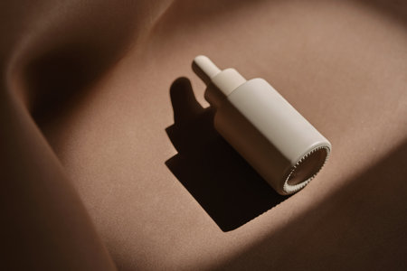 A bottle of face serum on a brown chocolate background.の写真素材